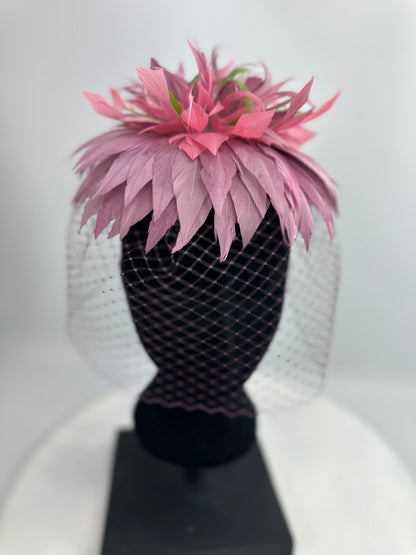 hat headpiece with purple and green feathers, purple veil netting on a white background