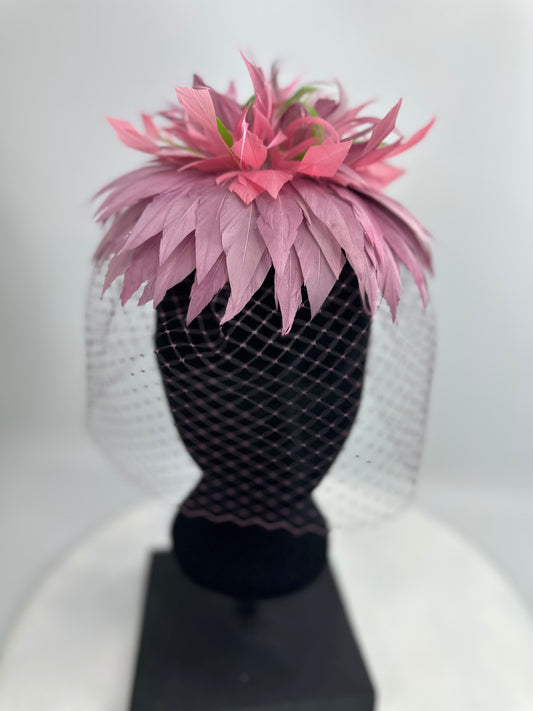 hat headpiece with purple and green feathers, purple veil netting on a white background