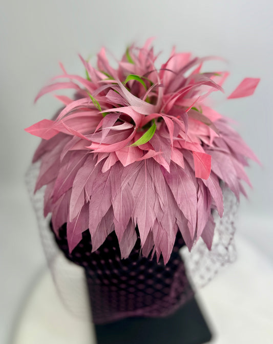 hat headpiece with purple and green feathers, purple veil netting on a white background
