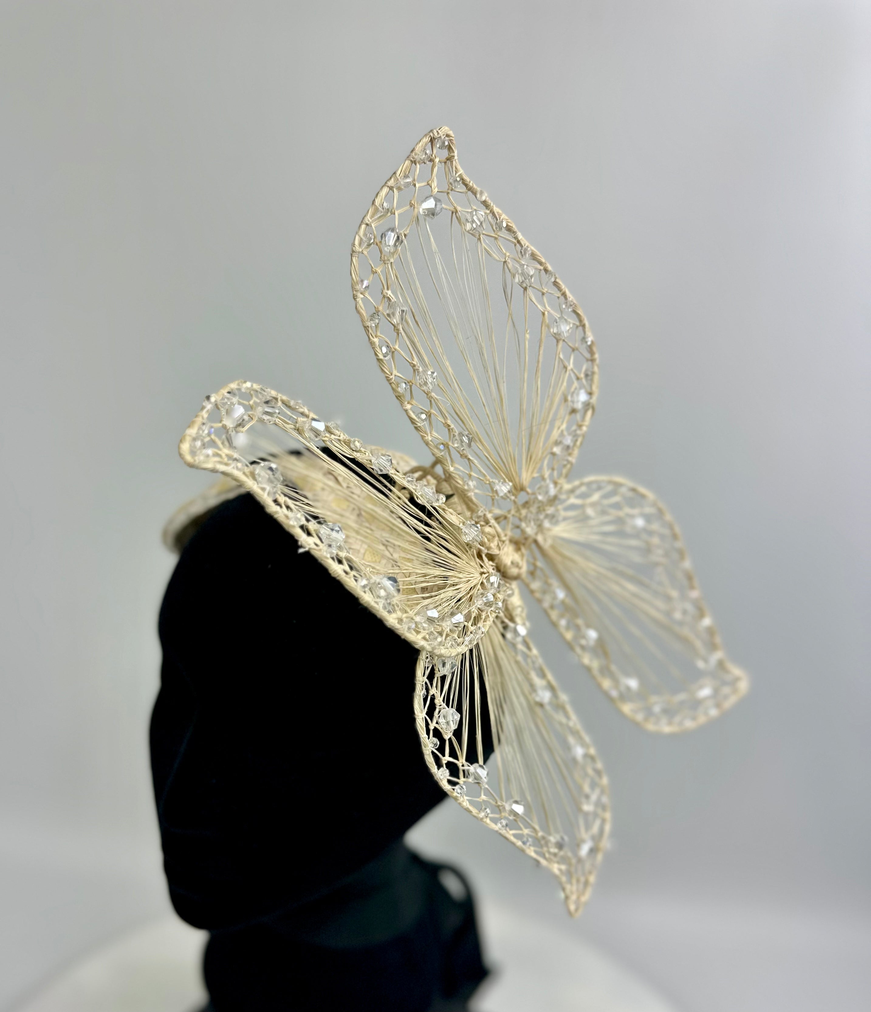 light gold butterfly-shaped woven hair accessory headband with rhinestones on a neutral background