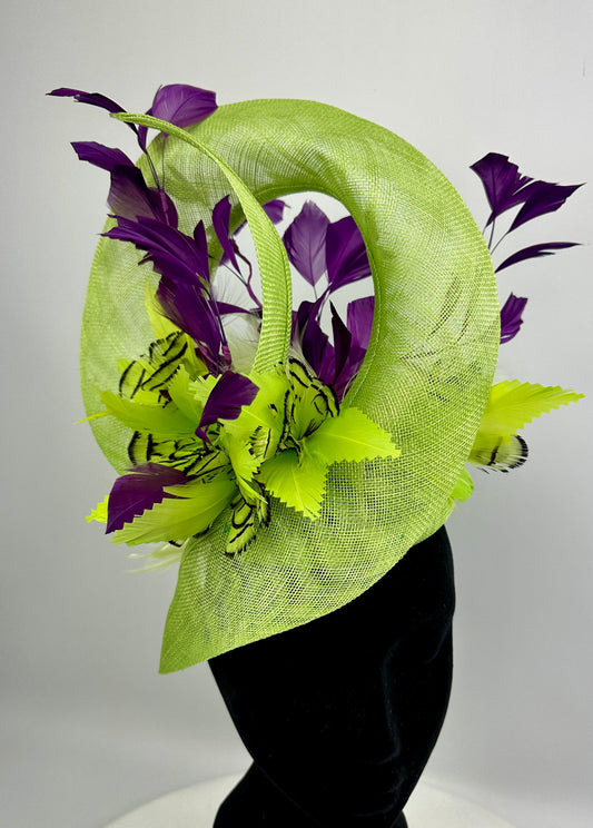 Fluro Green decorative headpiece hat with deep purple leaves and feathers on a white background