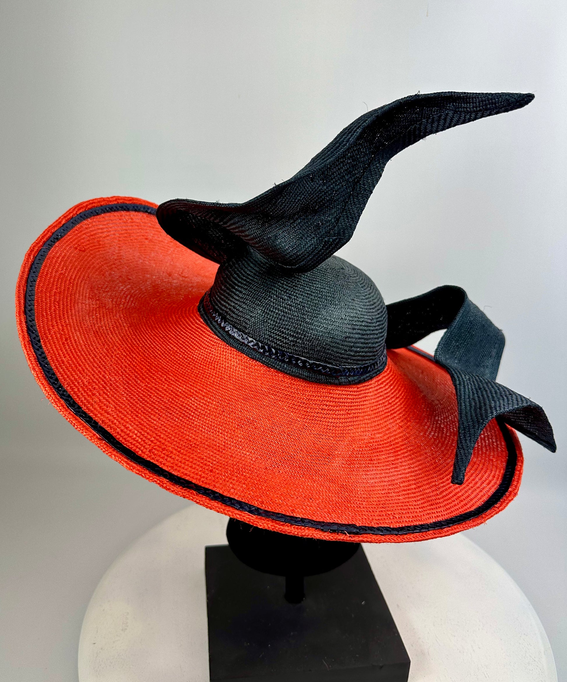 Orange sun hat with black brim and bow on a white background