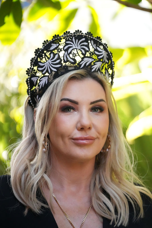Blonde woman wearing black and white lace crown with embroidery, trimming for special occassions and race day fashions on the field